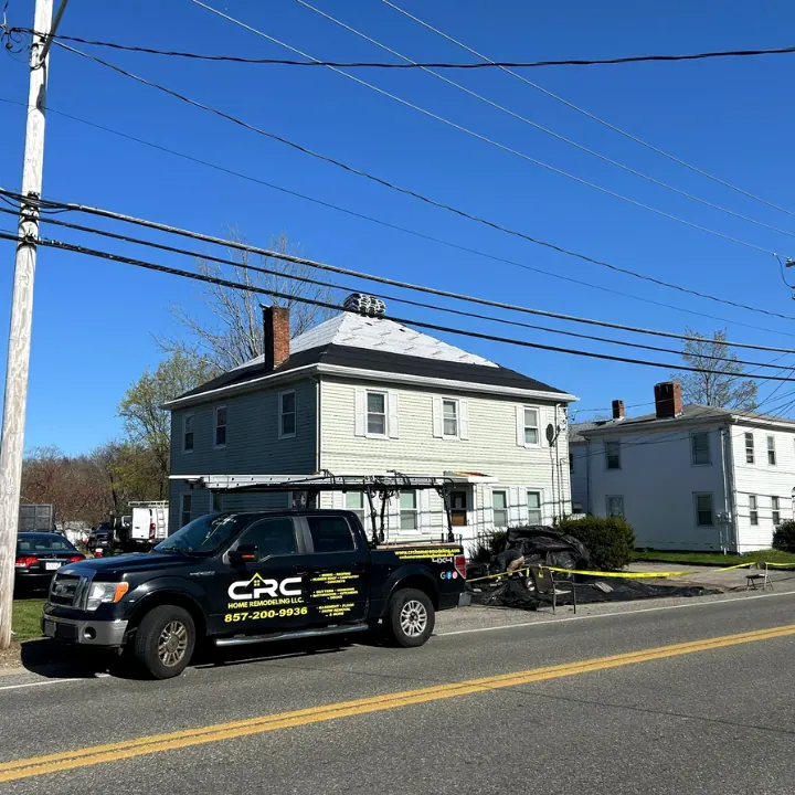 Black CRC company pickup on the street outside a two-story house under a blue sky