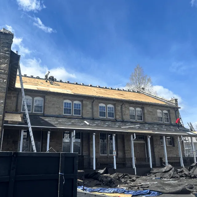 Roof tear-off on a large stone building, new roof decking going down