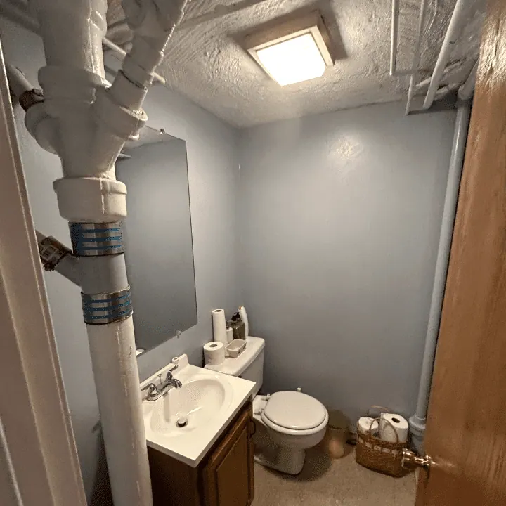 Small bathroom with a new vanity, toilet and light gray walls