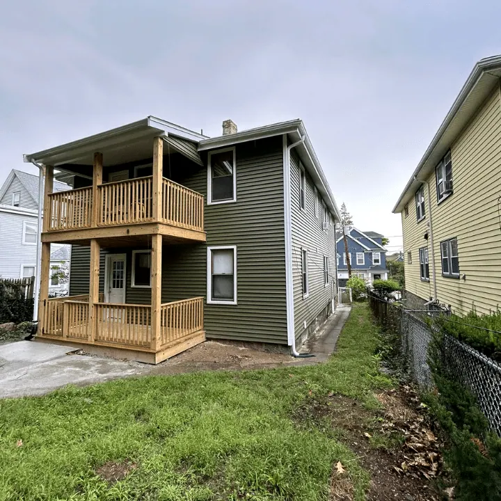 New two-story wood porches on a green-sided two-family house
